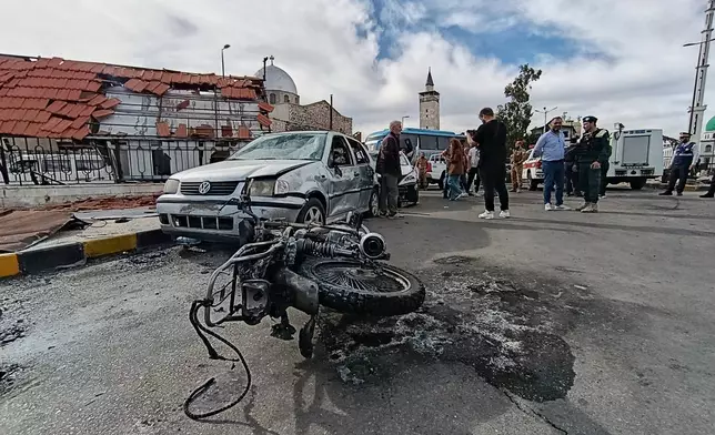 Syrian security personnel inspect the site of an explosion outside a Defense Ministry building in Damascus, Syria, Tuesday, May 19, 2026. (AP Photo/Abdulrahman Shaheen)