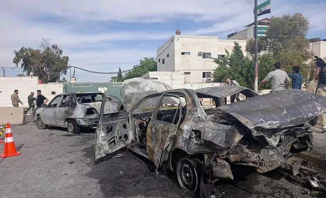 Syrian security personnel inspect the site of an explosion outside a Defense Ministry building in Damascus, Syria, Tuesday, May 19, 2026. (AP Photo/Abdulrahman Shaheen)