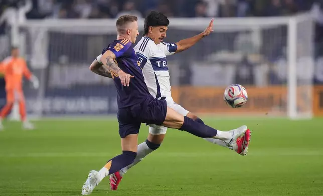 Los Angeles Galaxy midfielder Marco Reus, left, and Vancouver Whitecaps defender Mathias Laborda chase the ball during the first half of an MLS soccer match Saturday, May 2, 2026, in Carson, Calif. (AP Photo/Jae C. Hong)