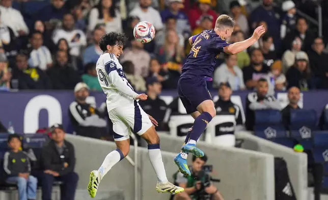 Vancouver Whitecaps midfielder Jeevan Badwal (59) heads the ball behind Los Angeles Galaxy defender John Nelson (14) during the first half of an MLS soccer match Saturday, May 2, 2026, in Carson, Calif. (AP Photo/Jae C. Hong)
