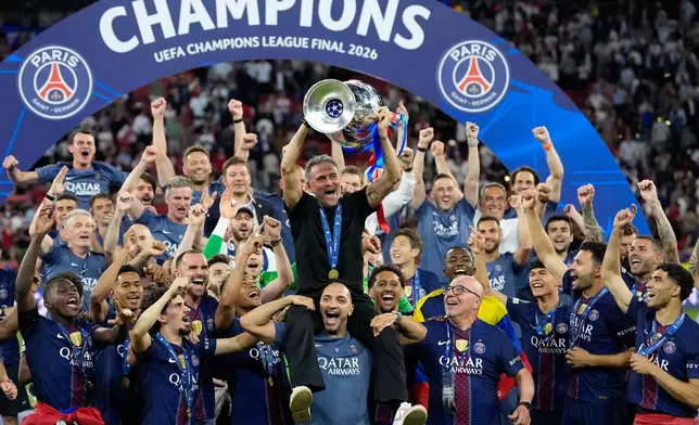 PSG's head coach Luis Enrique lifts the trophy celebrating after winning the Champions League final soccer match between Paris Saint-Germain and Arsenal in Budapest, Hungary, Saturday, May 30, 2026. (AP Photo/Petr Josek)