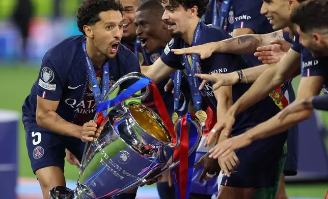 PSG players celebrate with a trophy after the Champions League final soccer match between Paris Saint-Germain and Arsenal in Budapest, Hungary, Saturday, May 30, 2026. AP Photo/Armin Durgut)