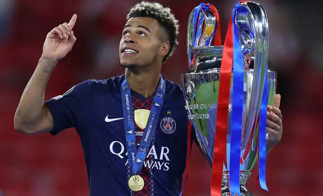 PSG's Desire Doue holds the trophy after the Champions League final soccer match between Paris Saint-Germain and Arsenal in Budapest, Hungary, Saturday, May 30, 2026. AP Photo/Armin Durgut)