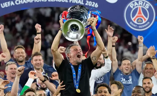 PSG's head coach Luis Enrique lifts the trophy celebrating after winning the Champions League final soccer match between Paris Saint-Germain and Arsenal in Budapest, Hungary, Saturday, May 30, 2026. (AP Photo/Petr Josek)