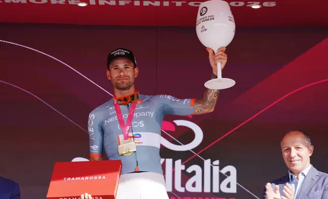 Italy's Filippo Ganna celebrates on the podium after winning the 10th stage of the Giro d'Italia cycling race from Viareggio to Massa, Italy, Tuesday May 19, 2026. (Gian Mattia D'Alberto/LaPresse via AP)