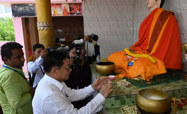 In this photo provided by Myanmar Military True News Information Team on Saturday, May 30, 2026, Myanmar President Min Aung Hlaing offers candles in front of a Buddha statue as he visits Bodh Gaya, in India on May 30. (Myanmar Military True News Information Team via AP)