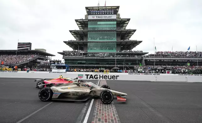Felix Rosenqvist, foreground, of Sweden, beats David Malukas to the finish line to win the Indianapolis 500 auto race at Indianapolis Motor Speedway in Indianapolis, Sunday, May 24, 2026. (AP Photo/AJ Mast)