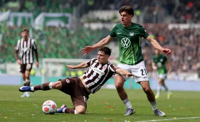 St. Pauli's Arkadiusz Pyrka, left, and Wolfsburg's Joakim Maehle fight for the ball during the German Bundesliga soccer match between FC St. Pauli and VfL Wolfsburg in Hamburg, Germany, Saturday, May 16, 2026. (Christian Charisius/dpa via AP)