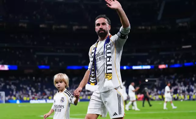 Real Madrid's Dani Carvajal ewalks ith his son during a farawell ceremony afyer his last macth for the club after a La Liga soccer match between Real Madrid and Athletic in Madrid, Spain, Saturday, May 23, 2026. (AP Photo/Manu Fernandez)