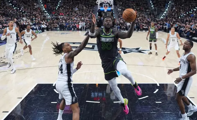 Minnesota Timberwolves forward Julius Randle (30) drives to the basket against San Antonio Spurs guard Devin Vassell (24) during the first half in Game 2 of a second-round NBA playoffs basketball series in San Antonio, Wednesday, May 6, 2026. (AP Photo/Eric Gay)