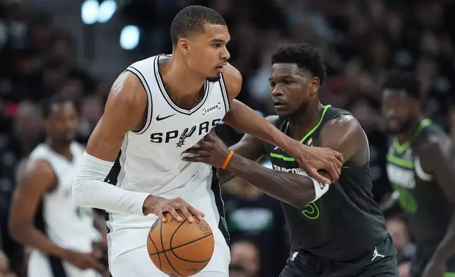 San Antonio Spurs forward Victor Wembanyama (1) drives against Minnesota Timberwolves guard Anthony Edwards (5) during the first half in Game 2 of a second-round NBA playoffs basketball series in San Antonio, Wednesday, May 6, 2026. (AP Photo/Eric Gay)