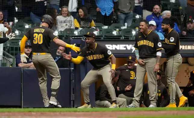San Diego Padres' Gavin Sheets (30) is congratulated in the dugout after hitting a three-run home run during the ninth inning of a baseball game against the Milwaukee Brewers, Wednesday, May 13, 2026, in Milwaukee. (AP Photo/Aaron Gash)
