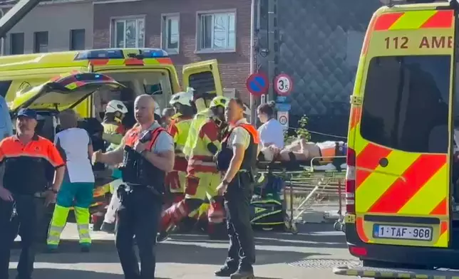 This video grab shows rescue workers on the scene of a crash between a train and vehicle in Buggenhout, Belgium, Tuesday, May 26, 2026. (VTM via AP)
