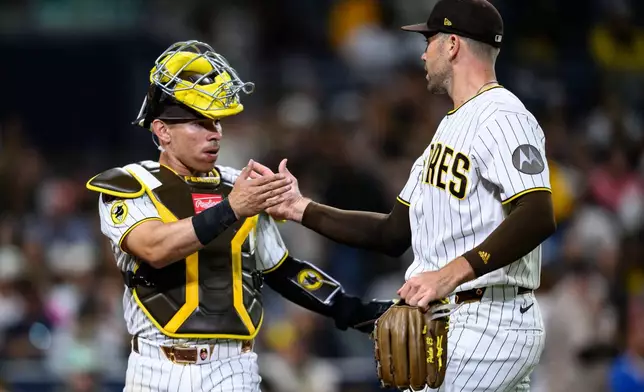 San Diego Padres pitcher Jason Adam, right, is greeted by catcher Freddy Fermin after striking out Athletics' Tyler Soderstrom during the eighth inning of a baseball game Saturday, May 23, 2026, in San Diego. (AP Photo/William Liang)