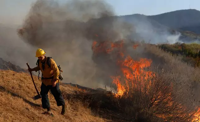 A firefighter conducts a firing operation, as the Sandy Fire approaches, Tuesday, May 19, 2026, in Simi Valley, Calif. (AP Photo/Caroline Brehman)