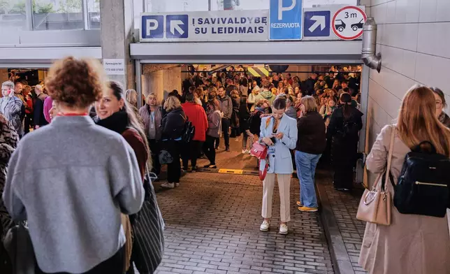 People take shelter in an underground car park during an air raid alert in Vilnius, Lithuania, Wednesday, May 20, 2026. (Vygintas Skaraitis/Lrytas via AP)