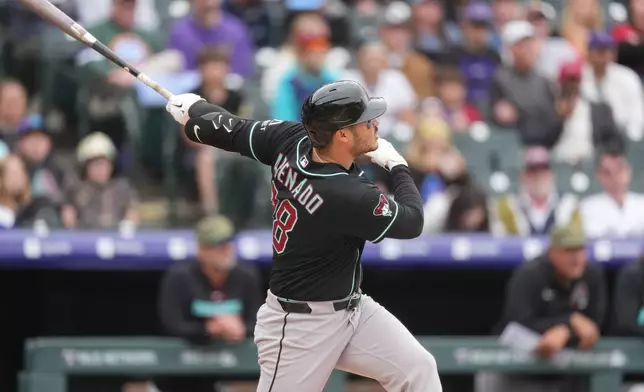 Arizona Diamondbacks' Nolan Arenado follows the flight of his RBI single off Colorado Rockies starting pitcher Michael Lorenzen in the third inning of a baseball game, Sunday, May 17, 2026, in Denver. (AP Photo/David Zalubowski)