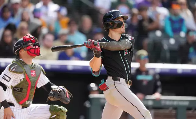 Arizona Diamondbacks' Corbin Carroll follows the flight of his two-run home run off Colorado Rockies starting pitcher Michael Lorenzen in the fourth inning of a baseball game, Sunday, May 17, 2026, in Denver. (AP Photo/David Zalubowski)