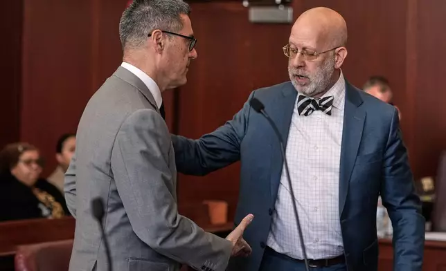 Manhattan Assistant District Attorney Alfred Peterson, left, prepares to shake hands with Arnold Levine, defense attorney for Randy Santos, after Santos was sentenced in court for fatally beating four sleeping men on the streets in 2019, in New York, Thursday, May 28, 2026. (AP Photo/Richard Drew)