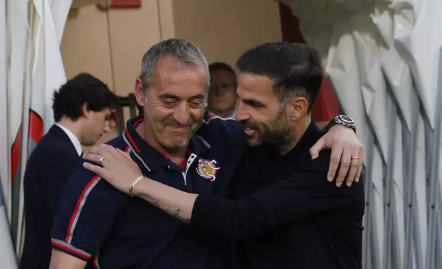 Cremonese's head coach Davide Nicola and Como's head coach Cesc Fabregas, right, greet each other ahead of the Serie A soccer match between Cremonese and Como in Cremona Italy, Sunday, May 24, 2026. (Alberto Mariani/LaPresse via AP)