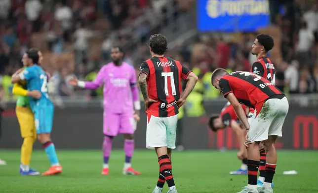 AC Milan's Christian Pulisic, left, reacts with his teammates Strahinja Pavlovic, center, and Zachary Athekame at the end of the Serie A soccer match between AC Milan and Cagliari, in Milan, Italy, Sunday, May 24, 2026. (AP Photo/Antonio Calanni)