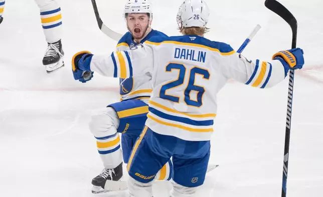 Buffalo Sabres' Zach Benson (6) celebrates his goal over Montreal Canadiens with teammate Rasmus Dahlin (26) during third period, second round, game 4, NHL playoff action in Montreal on Tuesday, May 12, 2026. (Christinne Muschi/The Canadian Press via AP)