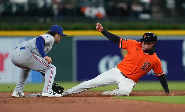 Detroit Tigers' Kerry Carpenter, right, steals second base under the tag of Texas Rangers second baseman Josh Smith, left, during the fifth inning of a baseball game Friday, May 1, 2026, in Detroit. (AP Photo/Paul Sancya)
