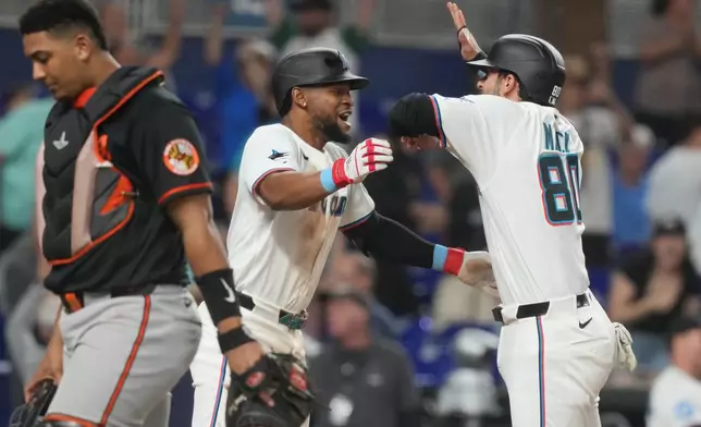 Miami Marlins' Joe Mack (80) and Otto Lopez (6) celebrate after defeating the Baltimore Orioles in the ninth inning of a baseball game Thursday, May 7, 2026, in Miami. (AP Photo/Marta Lavandier)