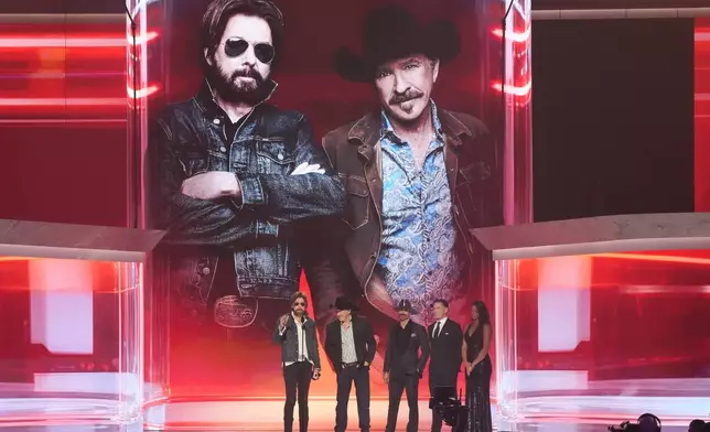 Ronnie Dunn, left, and Kix Brooks of "Brooks &amp; Dunn" accept the award for duo of the year during the 61st annual Academy of Country Music Awards on Sunday, May 17, 2026, at the MGM Grand Garden Arena in Las Vegas. Corey LaJoie and Carl Edwards look on from right.(AP Photo/Chris Pizzello)