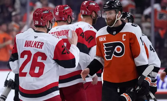 Philadelphia Flyers' Sean Couturier, right, and Carolina Hurricanes' Sean Walker meet after Game 4 in a second-round NHL hockey Stanley Cup playoff series Saturday, May 9, 2026, in Philadelphia. (AP Photo/Matt Slocum)