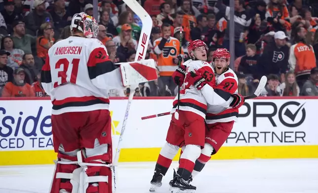 Carolina Hurricanes' Jackson Blake (53), Nikolaj Ehlers (27) and Frederik Andersen (31) celebrate after Blake's game-winning goal in overtime during Game 4 in a second-round NHL hockey Stanley Cup playoff series, Saturday, May 9, 2026, in Philadelphia. (AP Photo/Matt Slocum)