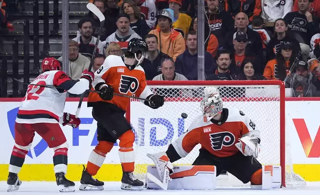 Philadelphia Flyers' Dan Vladar, right, cannot stop a goal by Carolina Hurricanes' Jackson Blake (not shown) as Flyers' Jamie Drysdale (9) and Hurricanes' Logan Stankoven, left, look on during the second period of Game 4 in a second-round NHL hockey Stanley Cup playoff series Saturday, May 9, 2026, in Philadelphia. (AP Photo/Matt Slocum)