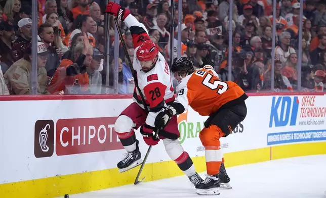 Carolina Hurricanes' William Carrier, left, tries to get past Philadelphia Flyers' Oliver Bonk, right, during the third period of Game 4 in a second-round NHL hockey Stanley Cup playoff series Saturday, May 9, 2026, in Philadelphia. (AP Photo/Matt Slocum)