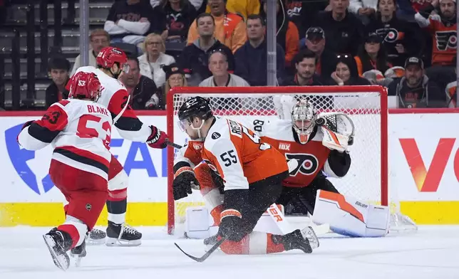 Carolina Hurricanes' Jackson Blake, left, scores the game-winning goal past Philadelphia Flyers' Dan Vladar (80) and Rasmus Ristolainen (55) in overtime during Game 4 in a second-round NHL hockey Stanley Cup playoff series, Saturday, May 9, 2026, in Philadelphia. (AP Photo/Matt Slocum)