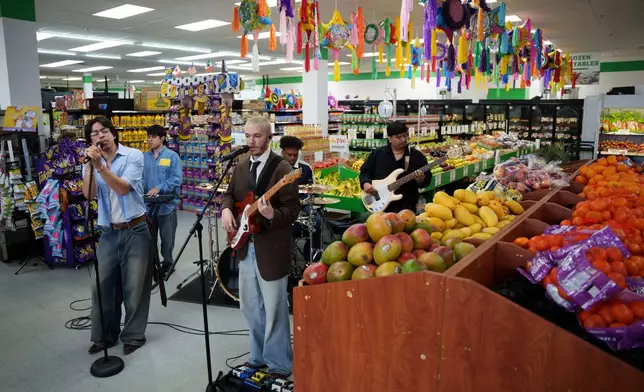 Bilingual alternative pop band Luna Luna performs in the produce section of Fiesta Fresh Market in New Castle, Del., on Sunday, April 26, 2026. (AP Photo/Mingson Lau)