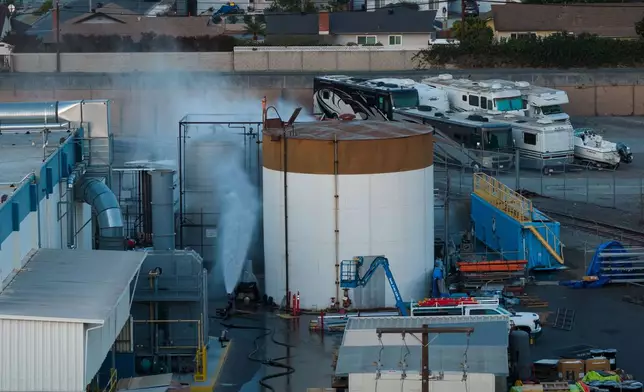 Water is sprayed on a tank that overheated at an aerospace plant in Garden Grove, Calif., Friday, May 22, 2026. (AP Photo/Ethan Swope)
