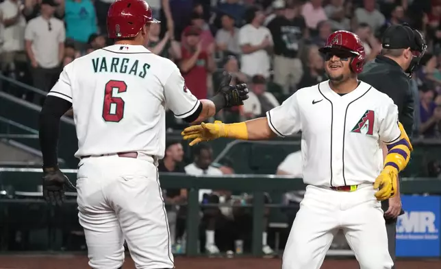 Arizona Diamondbacks' Gabriel Moreno, front right, celebrates with Ildemaro Vargas (6) after hitting a two-run home run against the San Francisco Giants in the fifth inning of a baseball game, Monday, May 18, 2026, in Phoenix. (AP Photo/Rick Scuteri)