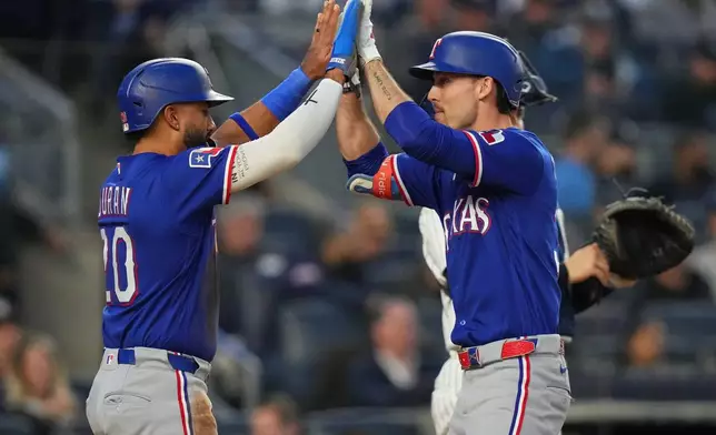 Texas Rangers' Evan Carter, right, celebrates with Ezequiel Duran after they scored on a two-run home run by Carter during the third inning of a baseball game against the New York Yankees, Wednesday, May 6, 2026, in New York. (AP Photo/Frank Franklin II)