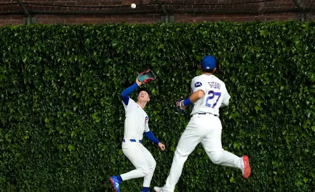Chicago Cubs center fielder Pete Crow-Armstrong, left, catches a fly ball hit by Milwaukee Brewers' William Contreras during the sixth inning of a baseball game in Chicago, Tuesday, May 19, 2026. (AP Photo/Nam Y. Huh)