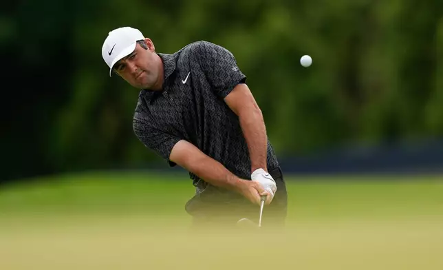 Scottie Scheffler chips onto the 13th green during a PGA Championship golf tournament practice round at Aronimink Golf Club, Wednesday, May 13, 2026, in Newtown Square, PA. (AP Photo/Carolyn Kaster)