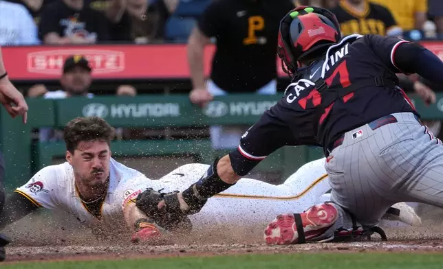 Pittsburgh Pirates' Konnor Griffin, left, slides around a tag by Minnesota Twins catcher Victor Caratini, right, to score on a single by Jake Mangum in the fifth inning of a baseball game in Pittsburgh, Saturday, May 30, 2026. (AP Photo/Tom E. Puskar)