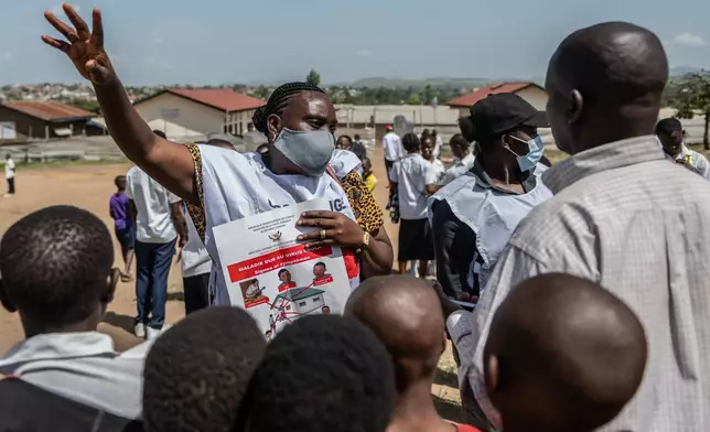 Vanny Birungi, a Red Cross volunteer, speaks to people during a public sensitisation campaign amid the Ebola outbreak in Bunia, Congo, Monday, May 25, 2026. (AP Photo/Moses Sawasawa)