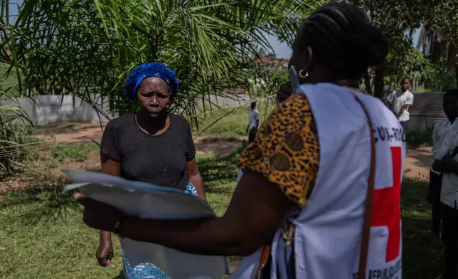Vanny Birungi, a Red Cross volunteer, speaks to a woman during a house-to-house sensitisation campaign amid the Ebola outbreak in Bunia, Congo, Monday, May 25, 2026. (AP Photo/Moses Sawasawa)