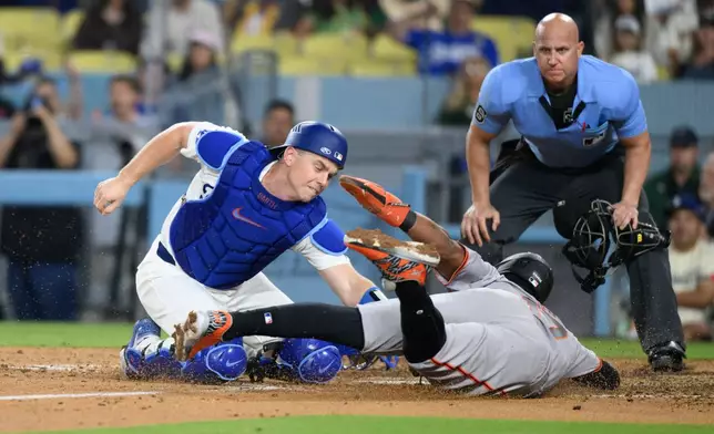 Los Angeles Dodgers catcher Will Smith, left, tags San Francisco Giants' Heliot Ramos out during the sixth inning of a baseball game in Los Angeles, Monday, May 11, 2026. (AP Photo/Kyusung Gong)