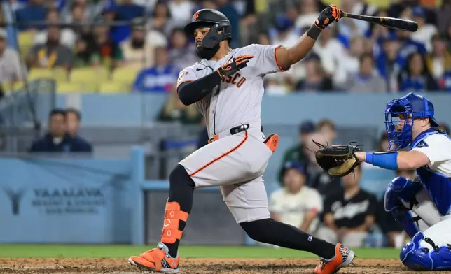 San Francisco Giants' Heliot Ramos hits a two-run double during the sixth inning of a baseball game against the Los Angeles Dodgers in Los Angeles, Monday, May 11, 2026. (AP Photo/Kyusung Gong)