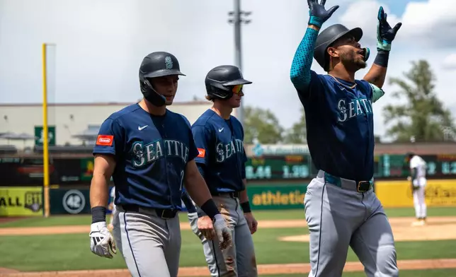 Seattle Mariners' Julio Rodríguez celebrates after hitting a home run during the eighth inning of a baseball game against the Athletics in West Sacramento, Calif., Wednesday, May 27, 2026. (AP Photo/Nic Coury)