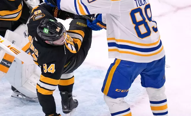 Boston Bruins left wing Tanner Jeannot (84) is upended by Buffalo Sabres right wing Alex Tuch (89) during the first period in Game 6 of a first-round NHL hockey Stanley Cup playoff series, Friday, May 1, 2026, in Boston. (AP Photo/Charles Krupa)