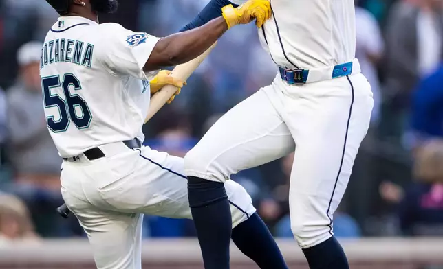Seattle Mariners' Julio Rodriguez, right, celebrates with Randy Arozarena (56) after hitting a solo home run during the third inning of a baseball game against the Arizona Diamondbacks, Saturday, May 30, 2026, in Seattle. (AP Photo/Stephen Brashear)