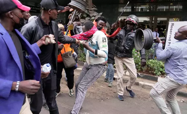 FILE - A suspected pro-government supporter is attacked by protesters during a demonstration over the death of blogger Albert Ojwang in police custody, in downtown Nairobi, Kenya, June 17, 2025. (AP Photo/Brian Inganga, File)