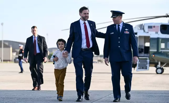 Vice President JD Vance and his son Vivek, are escorted as they walk to board Air Force Two at Joint Base Andrews, Md., Tuesday, May 5, 2026. Vance is traveling to Ohio, Oklahoma, and Iowa. (Roberto Schmidt /Pool Photo via AP)